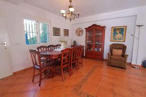 Un comedor con mesa y sillas de madera. en Casa Blanca - Mojacar Playa, en Mojácar