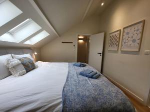 a bedroom with a large white bed with a window at Vakantiewoning 'Tranquille' Kortenaken in Kortenaken