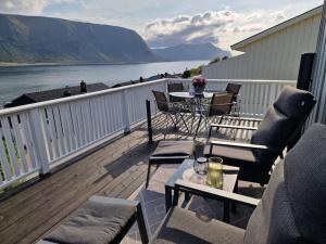 a balcony with a table and chairs and a view of the water at Hessahuset in Ålesund
