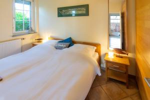 a bedroom with a white bed and a window at MeerBlau in Dornumersiel
