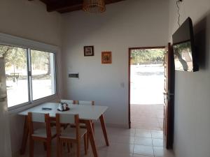 a dining room with a white table and chairs at Cabañas Cafayate in Cafayate