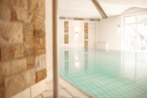 ein leerer Pool mit türkisfarbenem Boden in der Unterkunft Parkhotel Nümbrecht in Nümbrecht