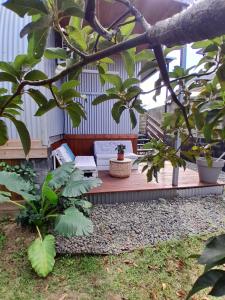 a porch with a bench in a garden with plants at Au bungalow in Saint-André