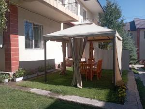a white umbrella on the lawn of a house at Dastan in Cholpon-Ata