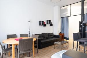 un soggiorno con un tavolo e un divano di Comfortable 49 m Apartment in the Heart of Paris a Parigi