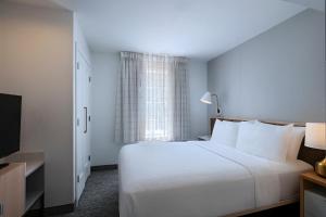 a bedroom with a white bed and a window at TownePlace Suites by Marriott College Station in College Station