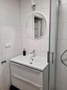 a white bathroom with a sink and a mirror at Axo-Hostel 13 in Stalowa Wola