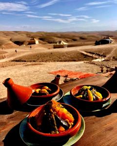 drei Schüsseln mit Essen auf einem Tisch in der Wüste in der Unterkunft Ngayan Camp in Marrakesch + 103 Fotos