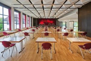 ein Klassenzimmer mit Tischen und Stühlen in einem Zimmer mit Fenstern in der Unterkunft Parkhotel Nümbrecht in Nümbrecht + 37 Fotos