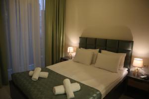 a bedroom with a bed with two crosses on it at Horizons Hotel Rooms in Batumi