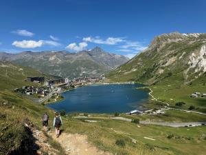 two people walking on a trail near a lake at Appartement Tignes Val claret in Tignes +7 photos