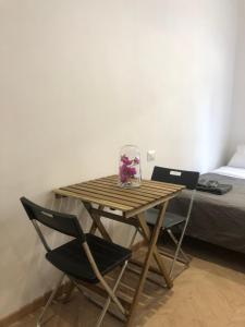 a wooden table with two chairs and a vase on it at Doberdó in Milan