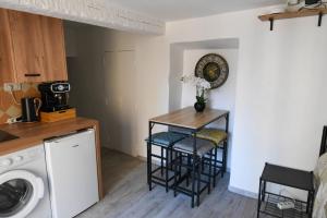 a small kitchen with a table and two stools at Les Chambres du Clavero in Claviers +5 photos