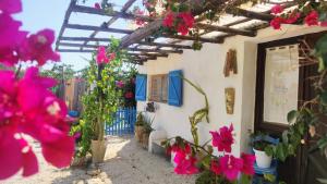 a white building with pink flowers on it at Sweet Old House in Marsala