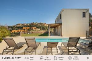 a group of chairs sitting around a swimming pool at Casa Ciudamar Costa Brava - BY EMERALD STAY in Begur