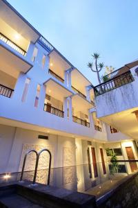 un gran edificio blanco con 2 balcones en Puri Padma Hotel, en Ubud