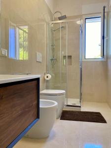 a bathroom with a shower and a toilet and a sink at Casa del Parco - Salento Homes in Melendugno