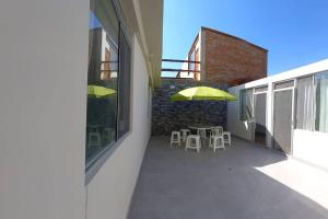 a balcony with a table and a yellow umbrella at Hermosa Casa en Mollendo in Mollendo