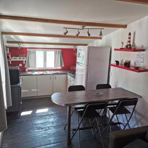 a kitchen with a table and chairs and a refrigerator at Mobil home hors camping 7km de la mer in Roquebrune-sur-Argens