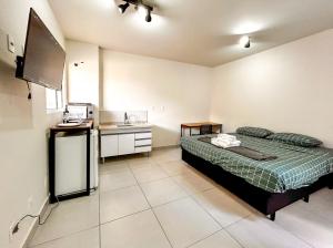 um pequeno quarto com uma cama e uma cozinha em Loft com WiFi otimo para Home Office - Sorocaba SP em Sorocaba