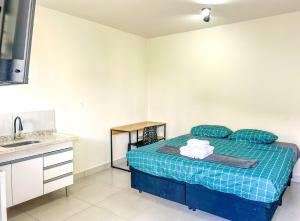um quarto com uma cama azul e um lavatório em Loft com WiFi otimo para Home Office - Sorocaba SP em Sorocaba