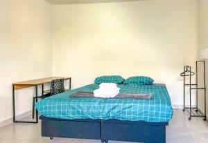 um quarto com uma cama com um cobertor azul e uma mesa em Loft com WiFi otimo para Home Office - Sorocaba SP em Sorocaba