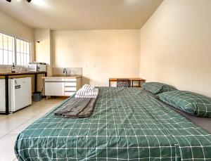 uma grande cama verde em um quarto com cozinha em Loft com WiFi otimo para Home Office - Sorocaba SP em Sorocaba mais 11 fotografias