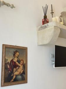 a painting of a woman with a baby on a wall at Dimora Santa Domenica in Scorrano