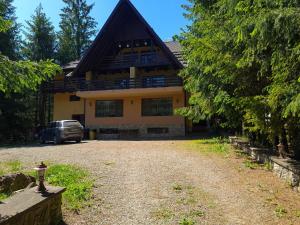 a house with a car parked in front of it at Vis de Munte in Mănăstirea Humorului