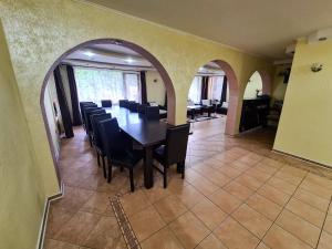a dining room with a long table and chairs at Vis de Munte in Mănăstirea Humorului