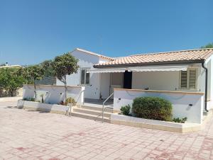a white house with stairs and plants in front of it at Villa IGMA in Siracusa