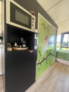 a microwave in a room with a bird painted on the wall at Eco-lodge nabij Giethoorn in Wanneperveen