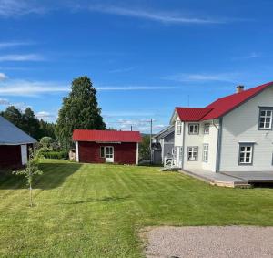 a yard with two houses and a red roof at Älvstugan in Övertorneå +10 photos