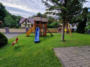 a playground with a slide and a play house at Apartmán Jantoľák in Zuberec