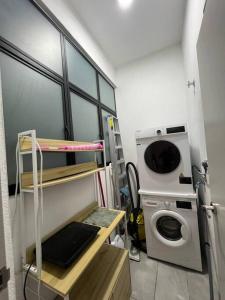 a laundry room with a washer and a washing machine at Fify Homestay in Putrajaya