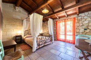 une chambre avec un lit, une table et une fenêtre dans l'établissement Masseria Copertini, à Vernole