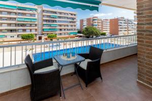 a balcony with a table and chairs and a swimming pool at Harmonia in Punta Prima