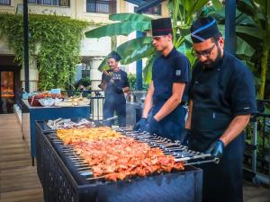 a group of chefs preparing food on a grill at Argisht Partez Hotel ALL INCLUSIVE & BEACH BAR REBLS in Golden Sands