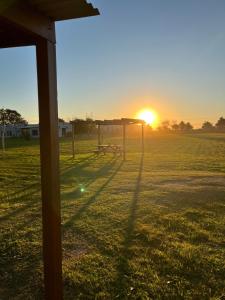 Una puesta de sol sobre un campo de fútbol con un gol en La Leontina, en Villa Elisa 33 fotos más