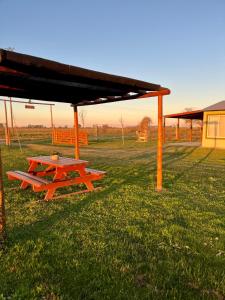 a picnic table under a roof in a field at La Leontina in Villa Elisa +33 photos