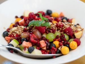 a white plate of fruit salad with a spoon at Mediterranean Villa Guesthouse in Cape Town +11 photos