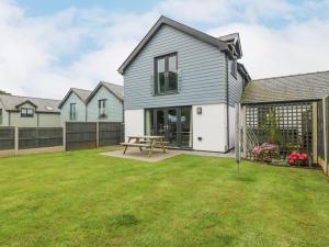 a house with a picnic table in a yard at 7 Parc Delfryn in Brynteg
