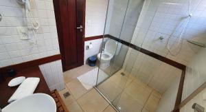 Un pequeño baño con inodoro y ducha. en Flat a 450 metros do centro - Praia da Pipa, en Pipa 20 fotos más