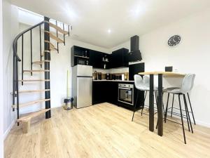 a kitchen with a table and a staircase in a room at Jungle Appartement avec terrasse in Laon