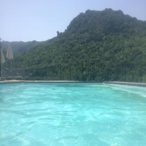una gran piscina de agua azul frente a una montaña en Saint Christophe en Omessa