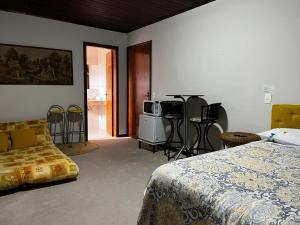 ein Schlafzimmer mit einem Bett und einem Tisch und Stühlen in der Unterkunft sonho de valsa in Campos do Jordão