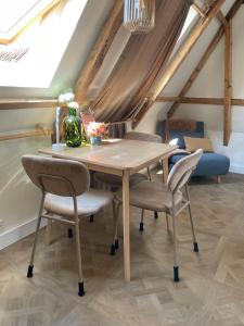 a dining room with a wooden table and chairs at B&B Suupmarkt in Dokkum +46 photos