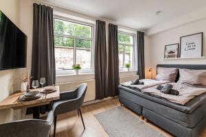 a bedroom with a bed and a desk and windows at SweetHome - Studio Apartments, super Zentral, Parkplatz in Eisenach