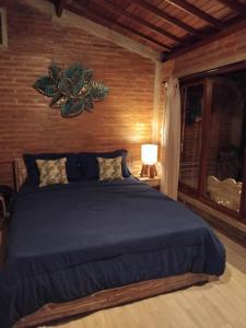 a bedroom with a large bed with a blue blanket at Umah mimpi in Tampaksiring
