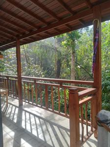 a wooden porch with a view of the forest at Umah mimpi in Tampaksiring +34 photos